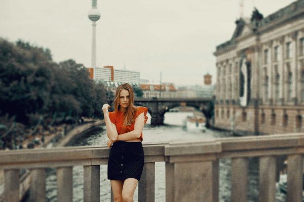 Female model standing next to the Bode Museum Berlin. On the background Berlin TV tower is visible