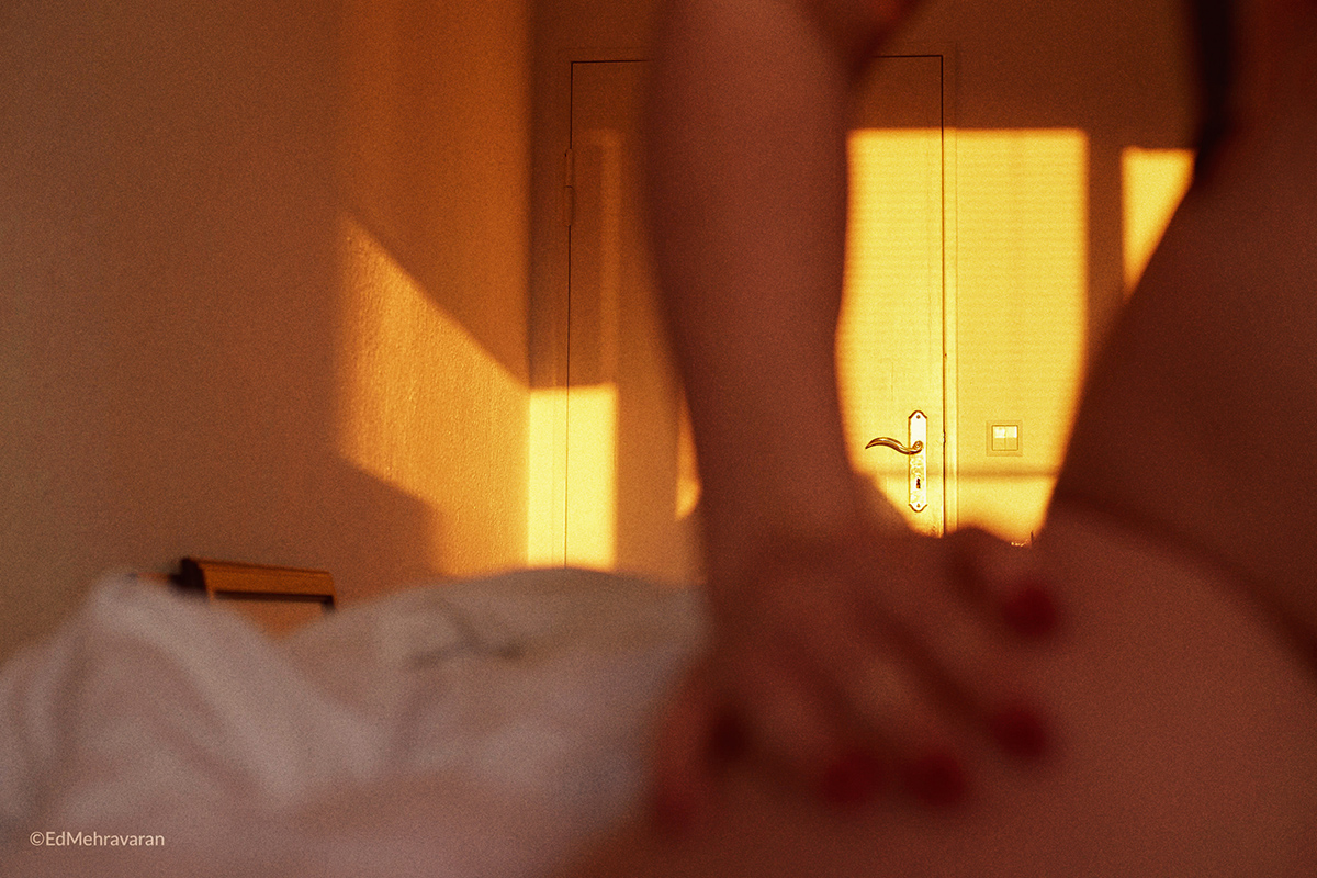 woman sitting on the bed with shadows of window