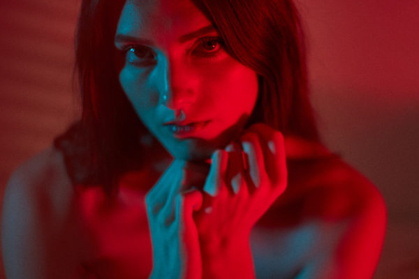 portrait of girl with red light on her face and body