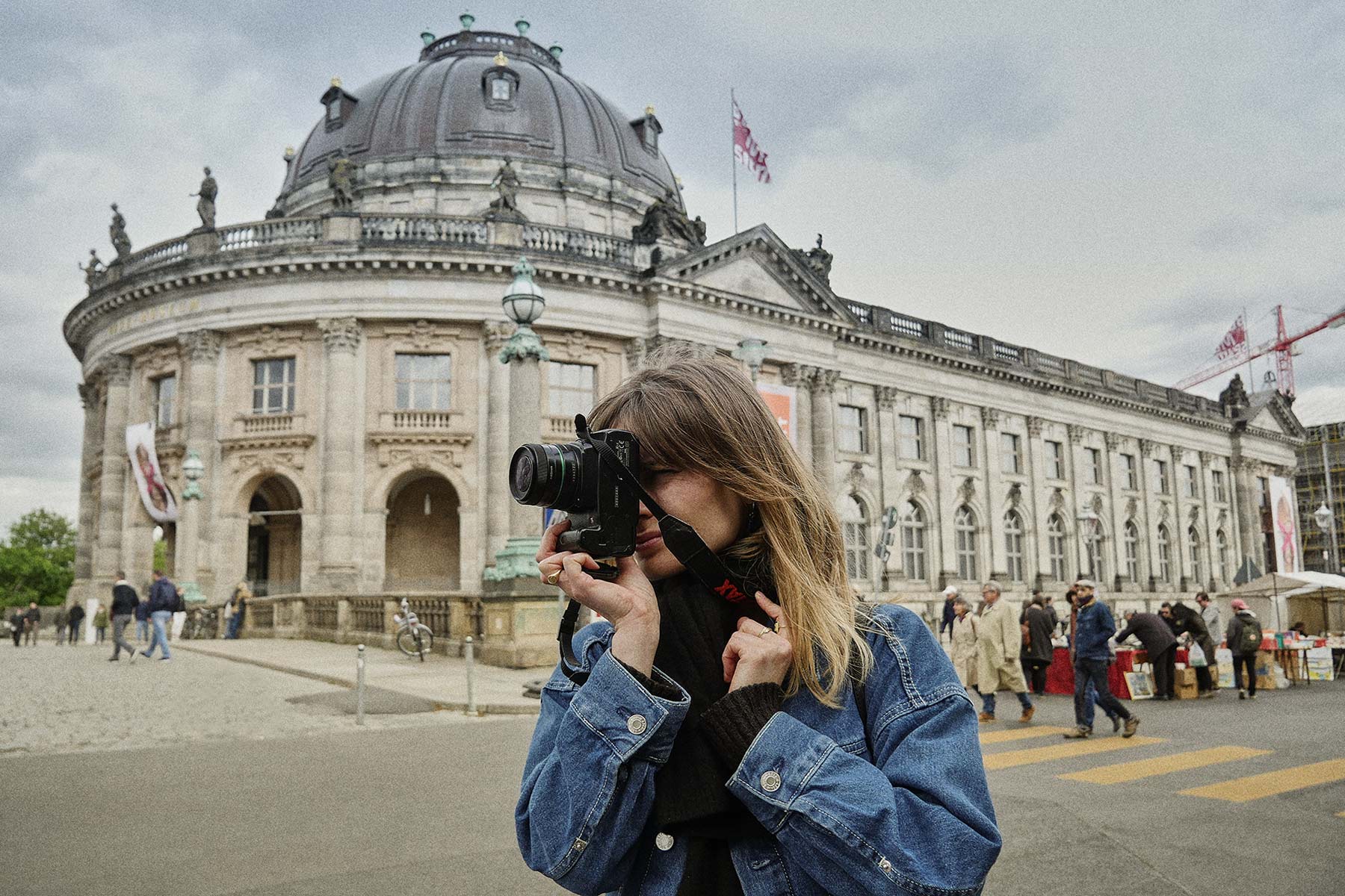 a Female photographer taking photo with her camera in front of Bode Museum in Berlin