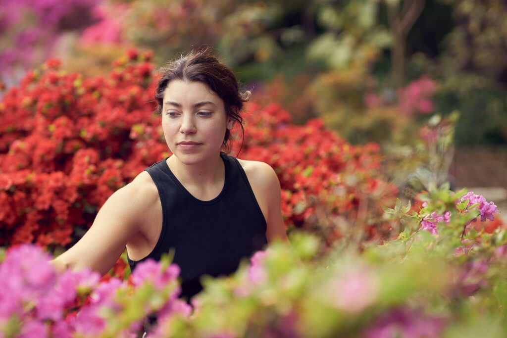 Portrait of Lea Schäfer in Botanical Garden in Berlin in Spring 2023 with Violet and red Flowers.