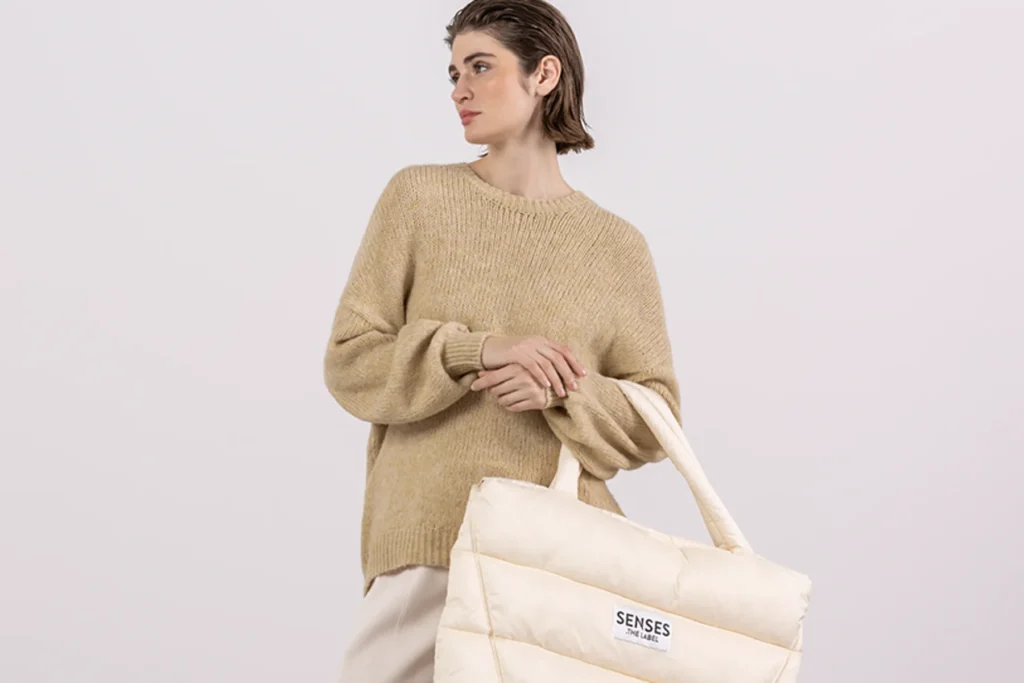 Female Model Holding cream color Bag from Senses The Label SS25