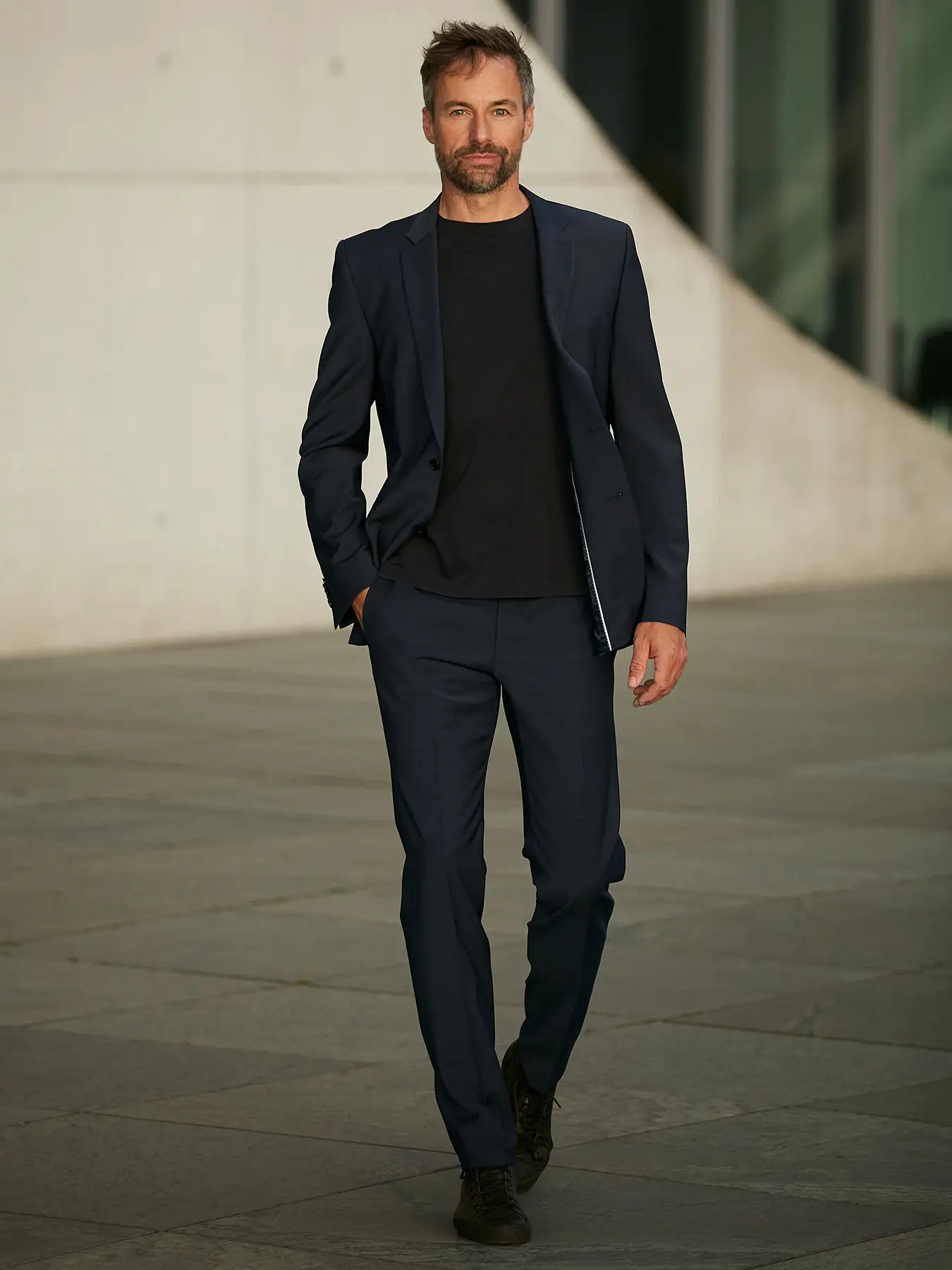 Außenporträt eines Mannes mit dunkelblauer Jacke auf dem Mauer-Mahnmal des Deutschen Bundestages