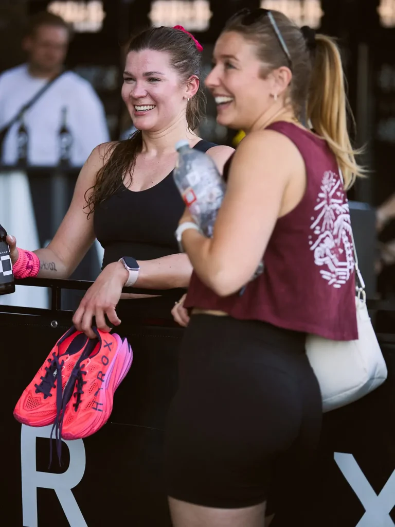 Female hierogs atletic Magda holding her high Rocks Puma shoes and smiling to a friend out of the frame next to her there was a female wearing magenta top