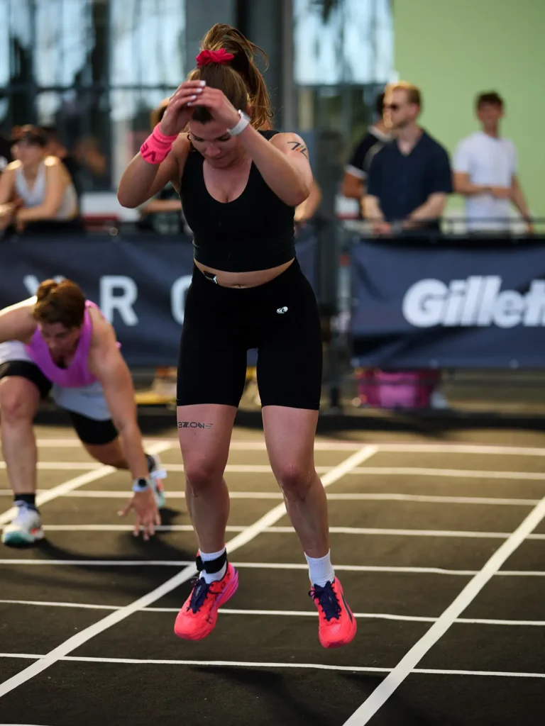Magdaa in Burpee broad jump station in HYROX Berlin. she is in jump position